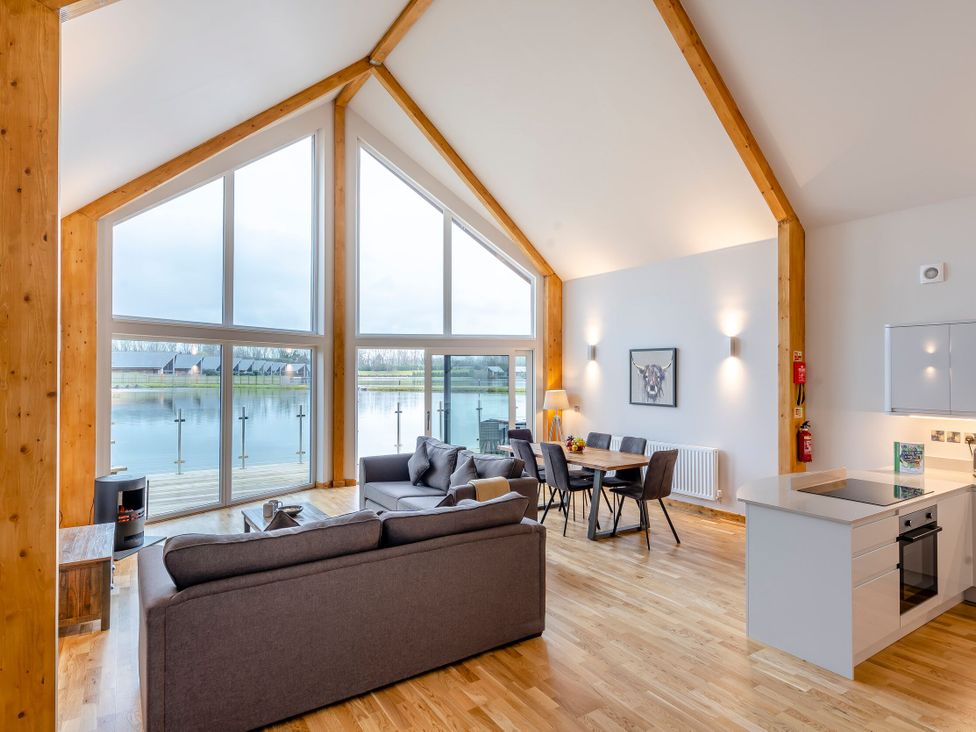 A living room with large windows and a dining area at Tranquillity 3 Warton near Carnforth