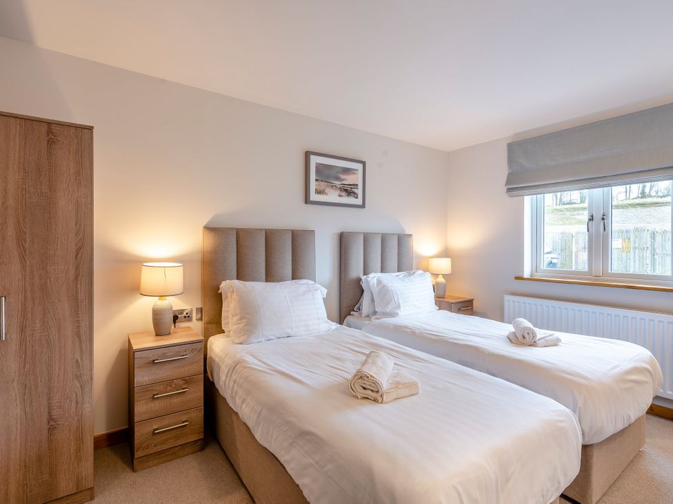 A bedroom with two beds and a window at Tranquillity 3 in Warton near Carnforth