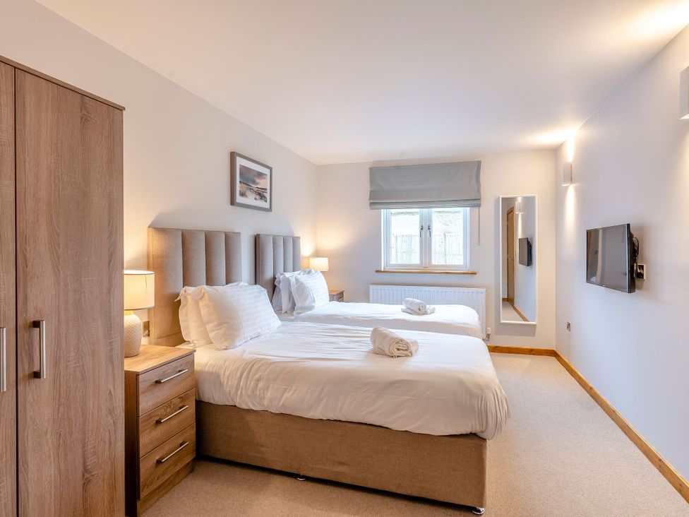 A bedroom with two beds and a wardrobe at Tranquillity 3 in Warton near Carnforth