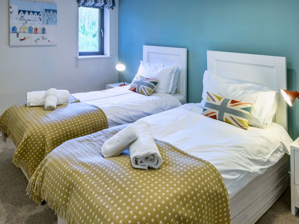 A bedroom with twin beds and a painting at Nan's House Spa in Marhamchurch