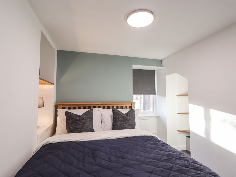 A bedroom with a bed and pillows at Wee Flat in Avoch