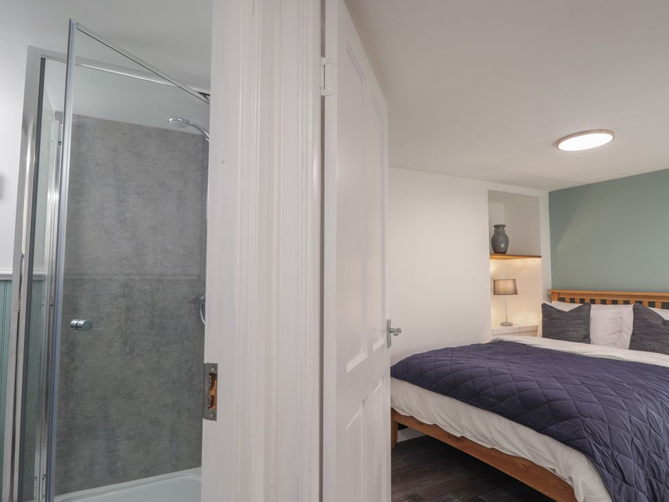 A bedroom with a door and a shower at Wee Flat in Avoch