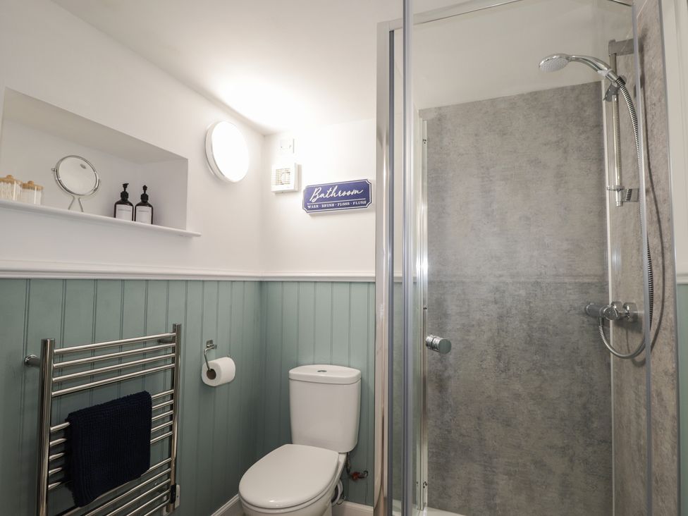 A bathroom featuring a toilet and shower at Wee Flat in Avoch