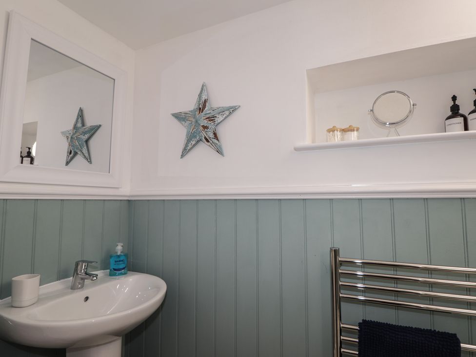 A bathroom with a sink and decorative elements at Wee Flat in Avoch