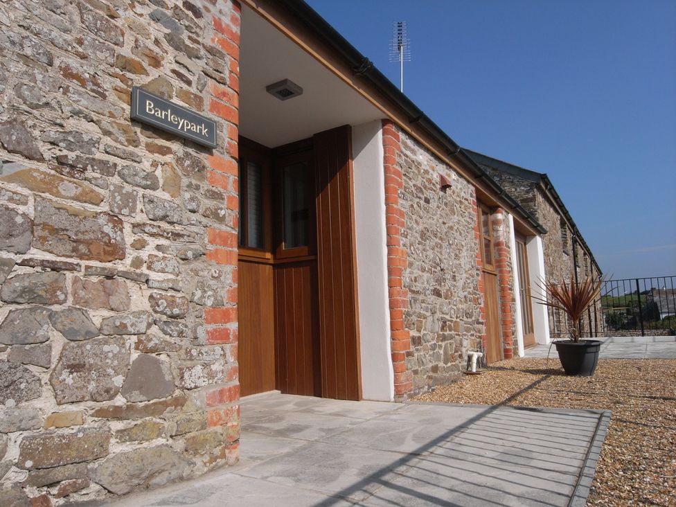 An exterior view of Barleypark with stone walls and a door in Marhamchurch