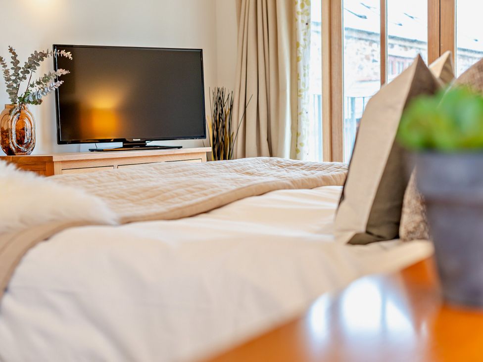 A bedroom with a television and bed at Barley Park in Marhamchurch
