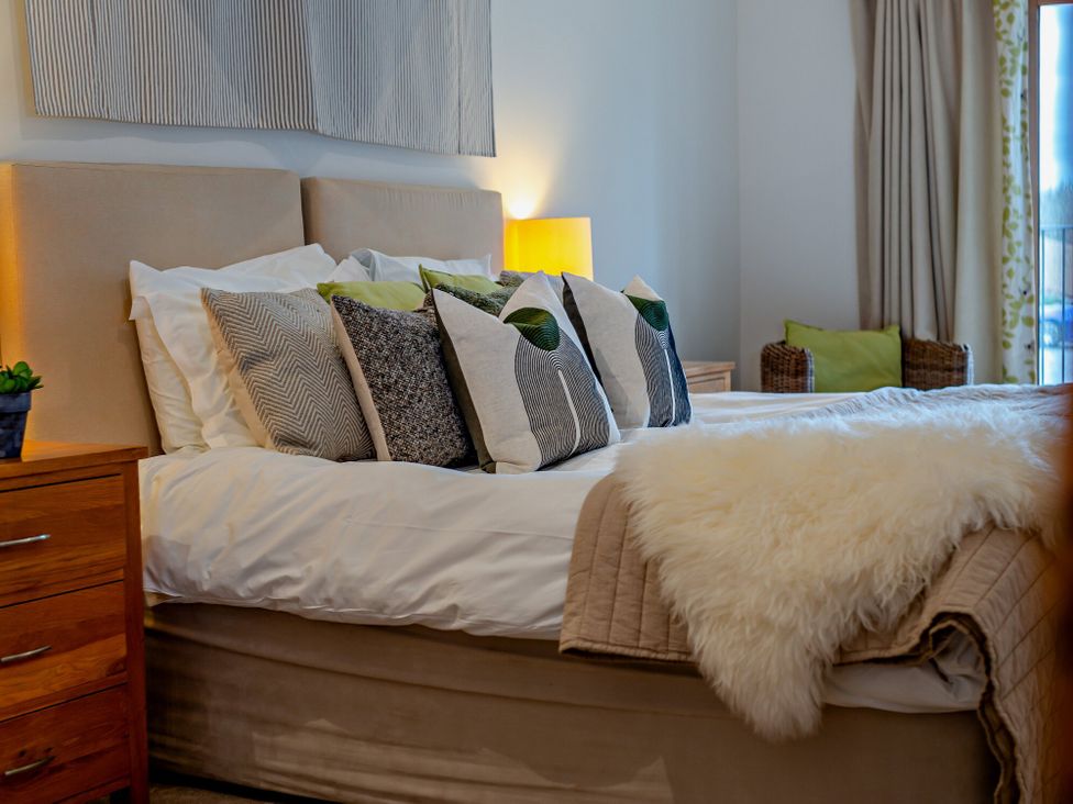 A bedroom with a bed and decorative pillows at Barley Park in Marhamchurch