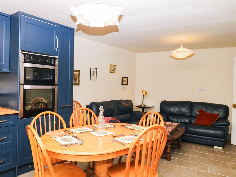 A kitchen with dining table and sofa at The Gables in Teignmouth