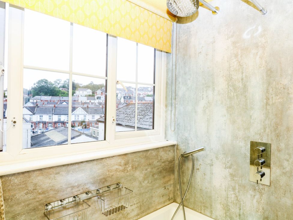 A bathroom with a bathtub and a window at The Gables in Teignmouth