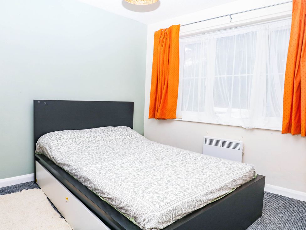 A bedroom with a bed and window at The Gables in Teignmouth