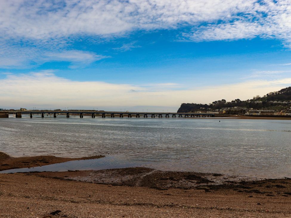 A view of a bridge over water with a beach and houses at The Gables in Teignmouth