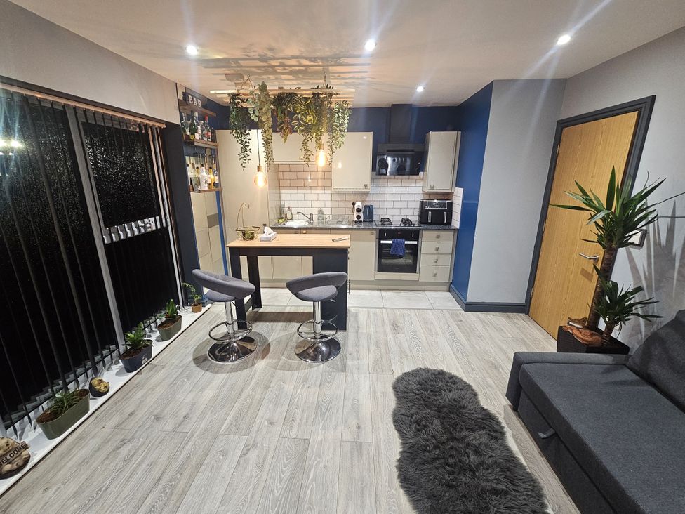 A kitchen with bar stools and a dining table at Cosy Southampton Apartment in Southampton