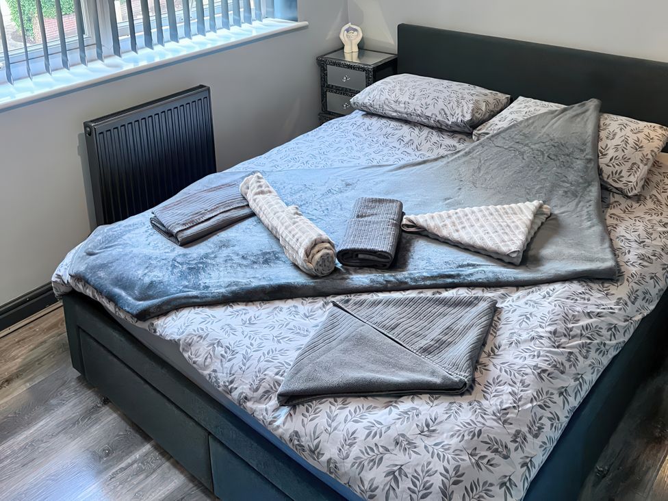 A bedroom with a bed made up with sheets and towels at Cosy Southampton Apartment Southampton