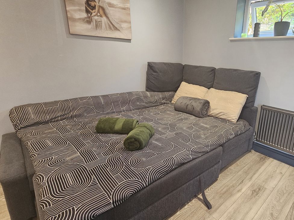A sofa with pillows and towels in a living room at Cosy Southampton Apartment Southampton