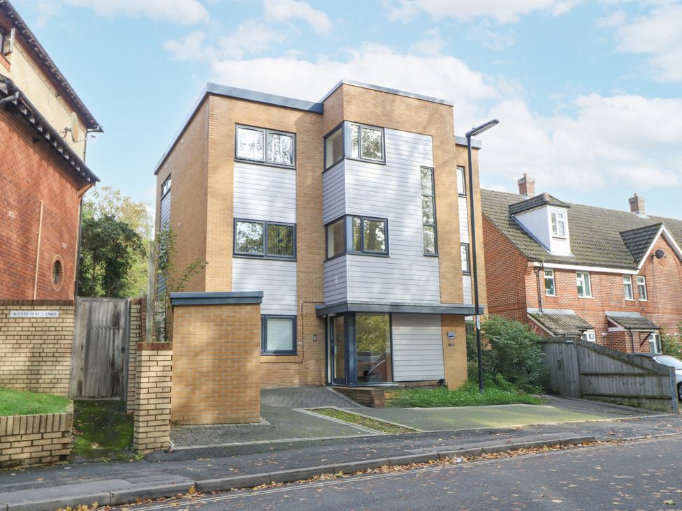 A modern building with multiple windows and a parking area at Cosy Southampton Apartment in Southampton