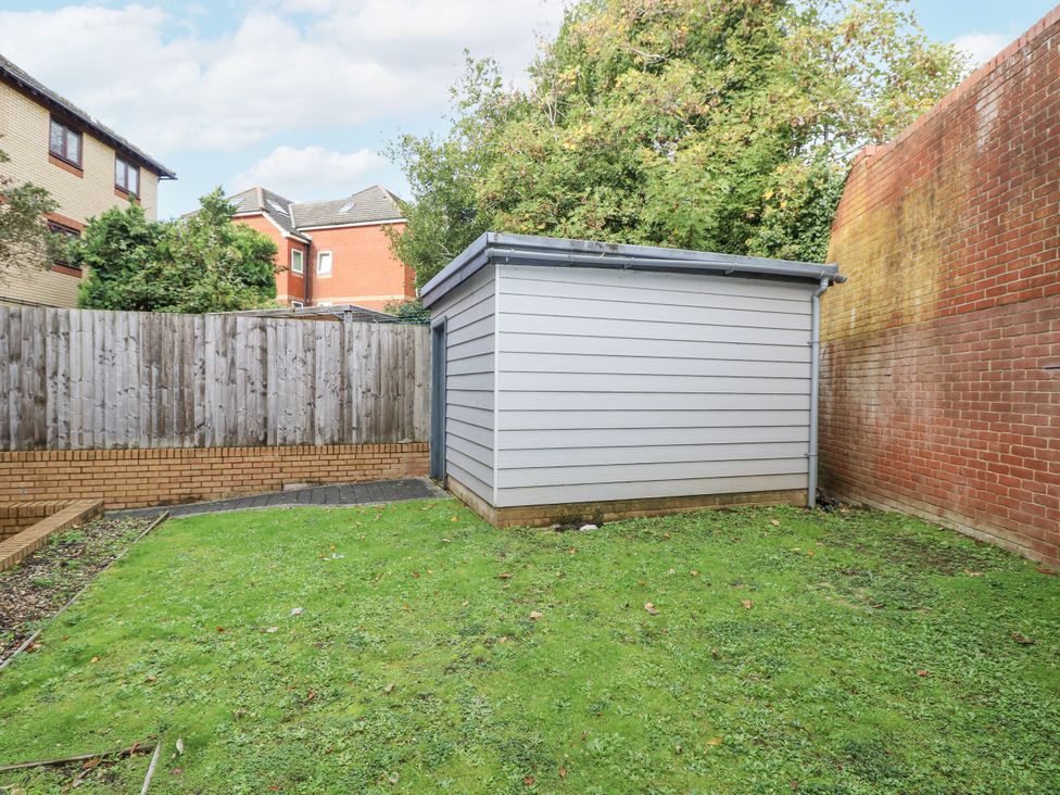 A garden with a shed and grass area at Cosy Southampton Apartment in Southampton
