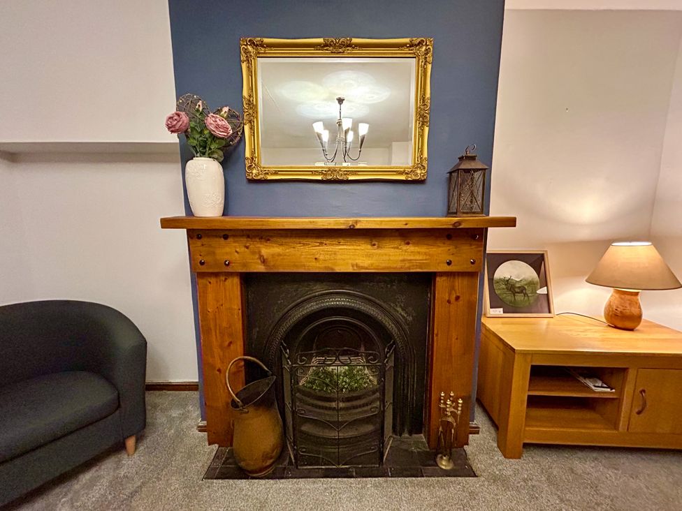 A living room with a fireplace and mirror at Scamnel in Eccleshall