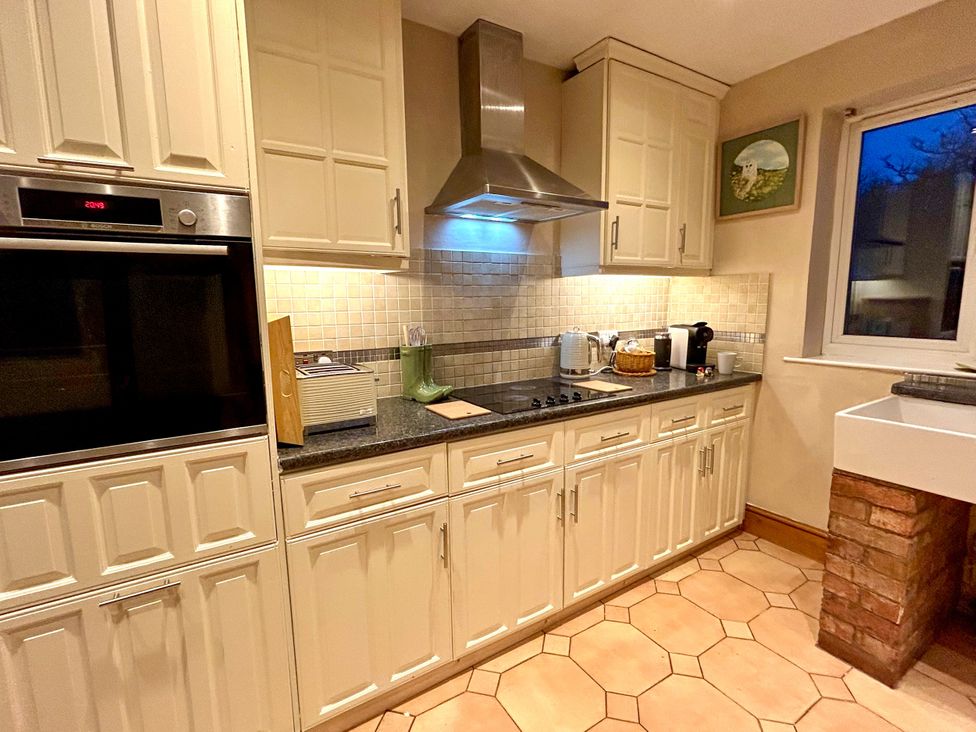 A kitchen with cabinets, stove, and sink at Scamnel in Eccleshall