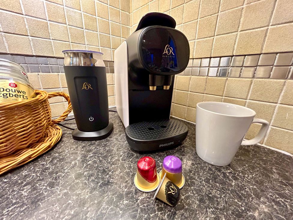 A coffee machine with milk frother and coffee capsules in a kitchen at Scamnel Eccleshall