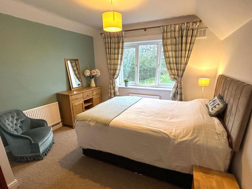 A bedroom with a bed and chair at Scamnel in Eccleshall