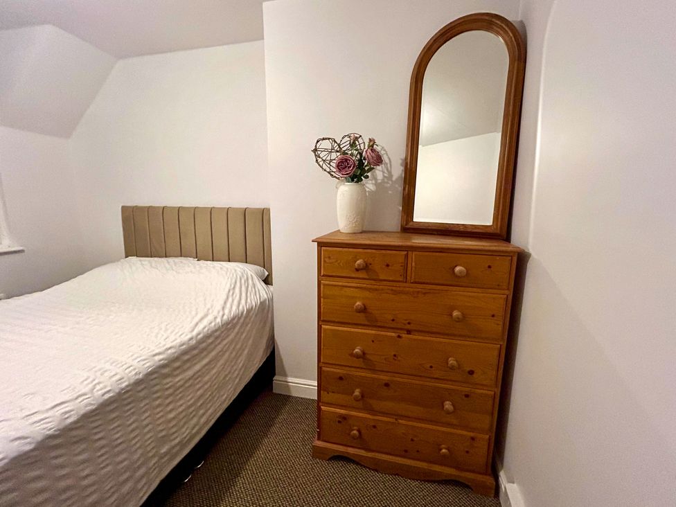 A bedroom with a bed, dresser, and mirror at Scamnel, Eccleshall