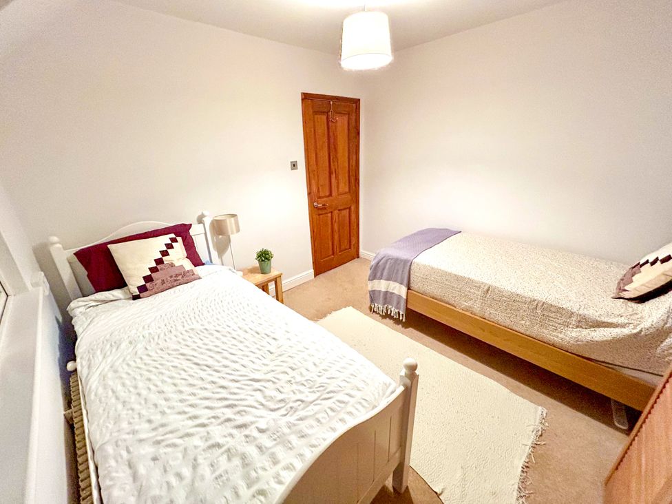 A bedroom with two beds and a lamp at Scamnel in Eccleshall