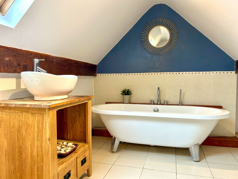 A bathroom with a bathtub and sink at Scamnel in Eccleshall