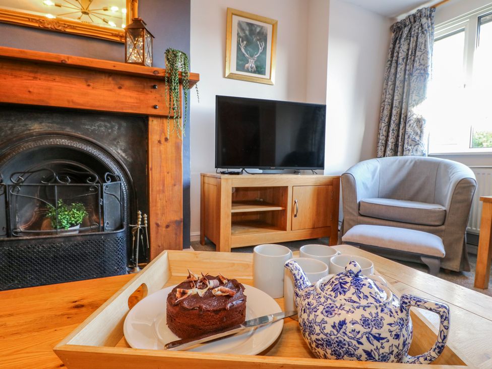 A living room with a fireplace and a coffee table at Scamnel in Eccleshall