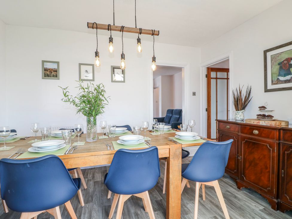 A dining room with a table set for meals and sideboard at Scamnel in Eccleshall