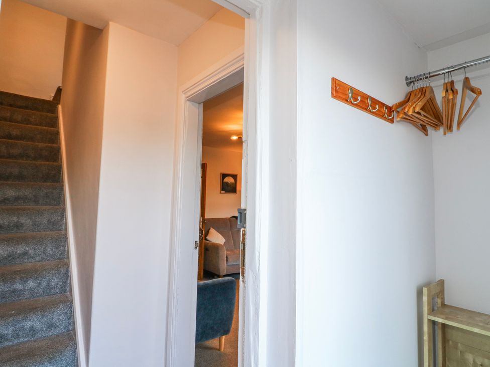 A hallway with stairs, a coat rack and a view of a room at Scamnel in Eccleshall