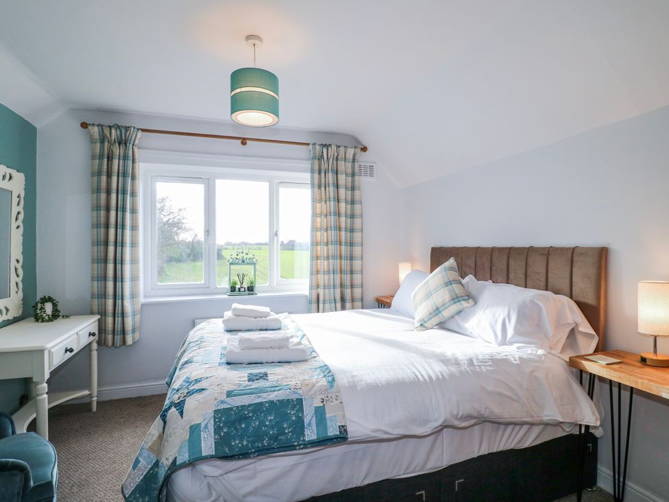 A bedroom with a double bed and a desk at Scamnel in Eccleshall