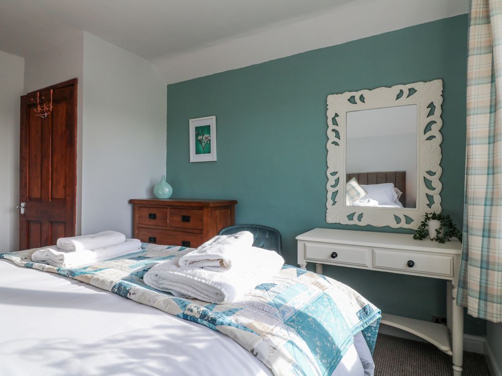 A bedroom with a bed and mirror at Scamnel in Eccleshall