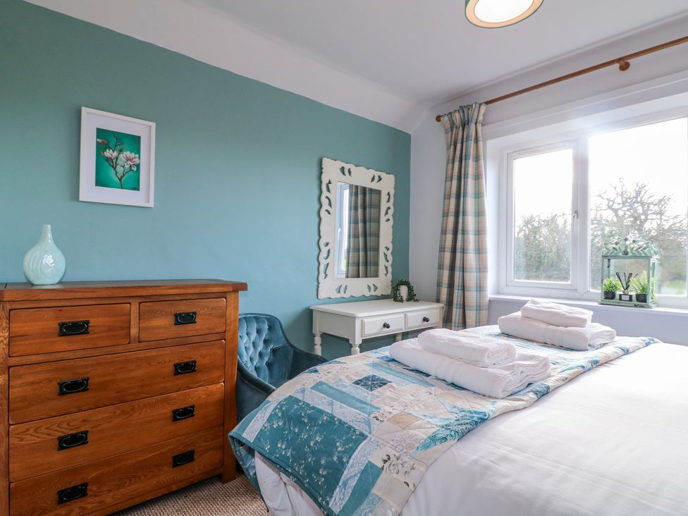 A bedroom with a bed and dresser at Scamnel in Eccleshall