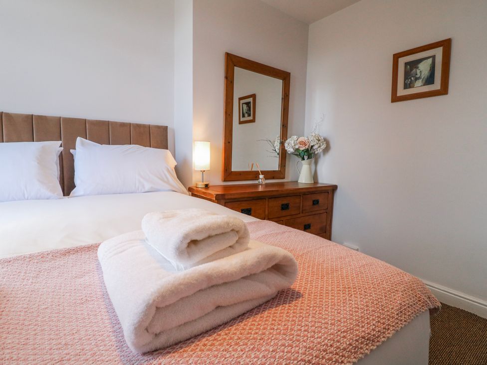 A bedroom with a bed and a dressing table at Scamnel in Eccleshall