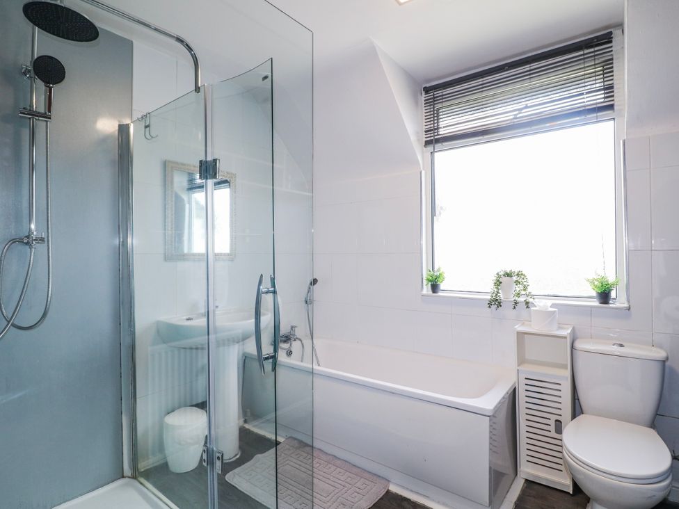 A bathroom with a shower, bathtub, sink, and toilet at Scamnel in Eccleshall