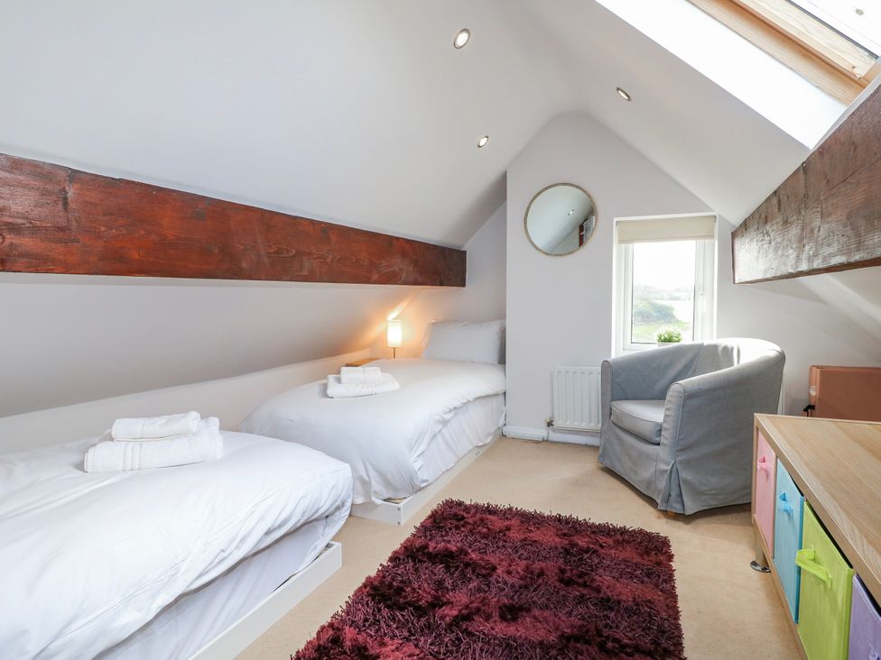 A bedroom with two beds and an armchair at Scamnel in Eccleshall