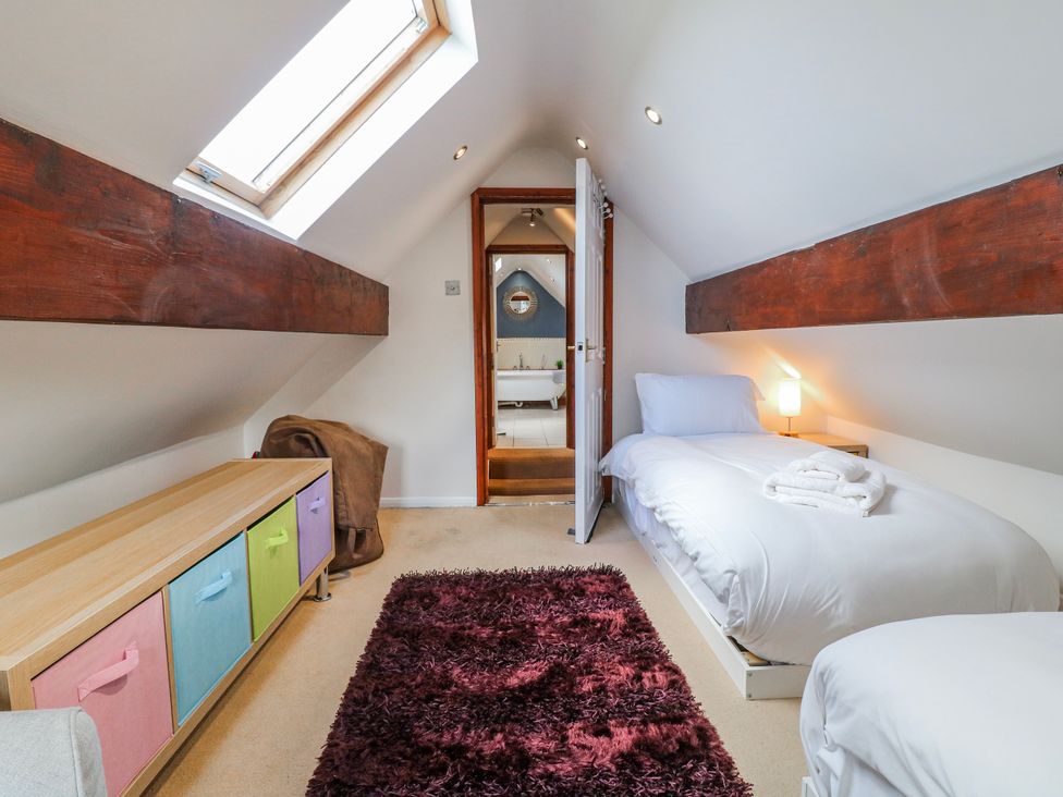 A bedroom with two beds and a storage unit at Scamnel in Eccleshall