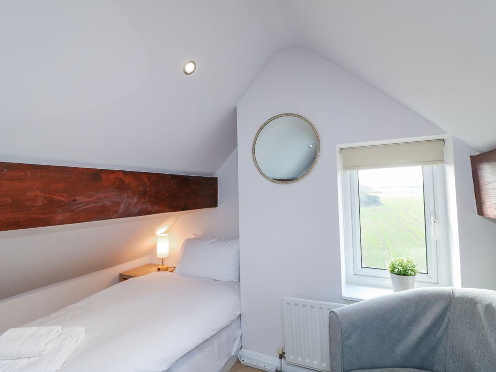 A bedroom with a bed and window at Scamnel in Eccleshall