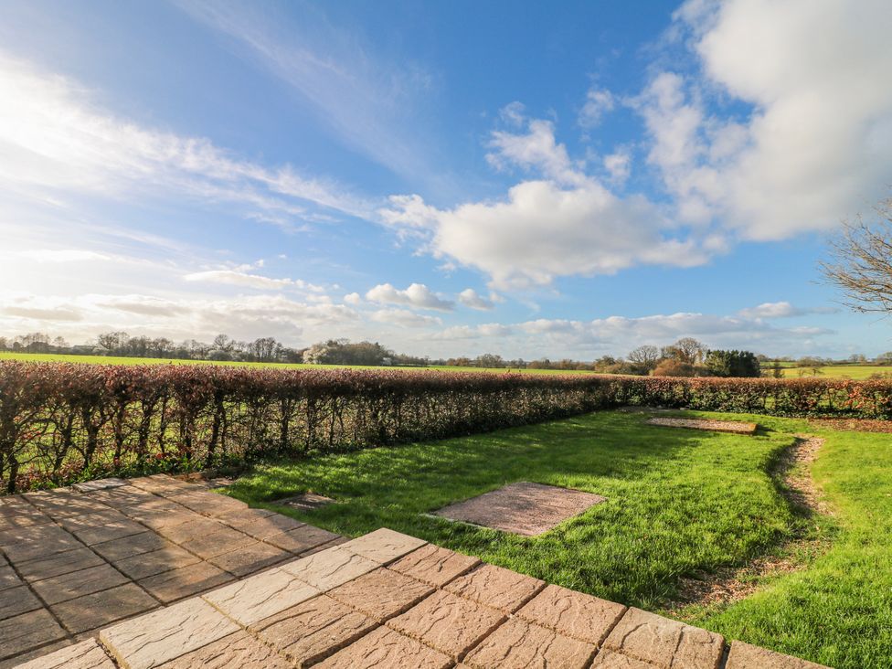 A garden area with grass and paving stones at Scamnel, Eccleshall