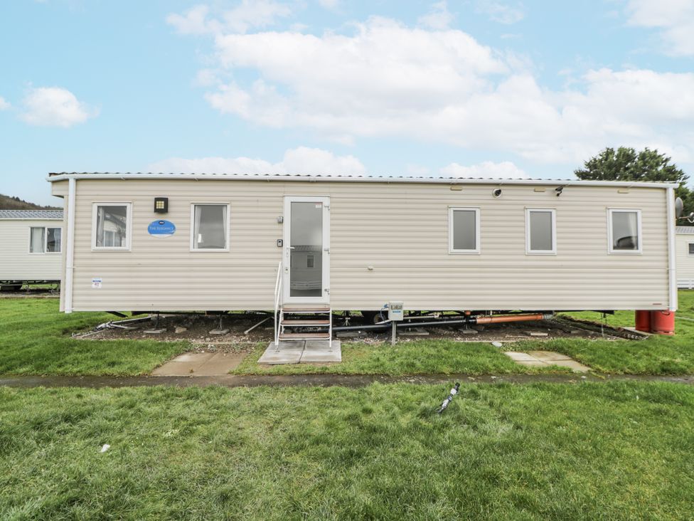 A mobile home with a front door and windows at Brynowen Holiday Park - Holiday Accommodation 22432 Borth