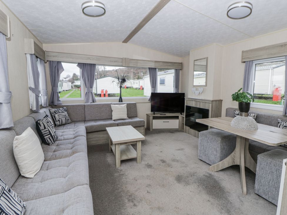 A living room with a sofa TV and dining table at Brynowen Holiday Park - Holiday Accommodation 22432 Borth