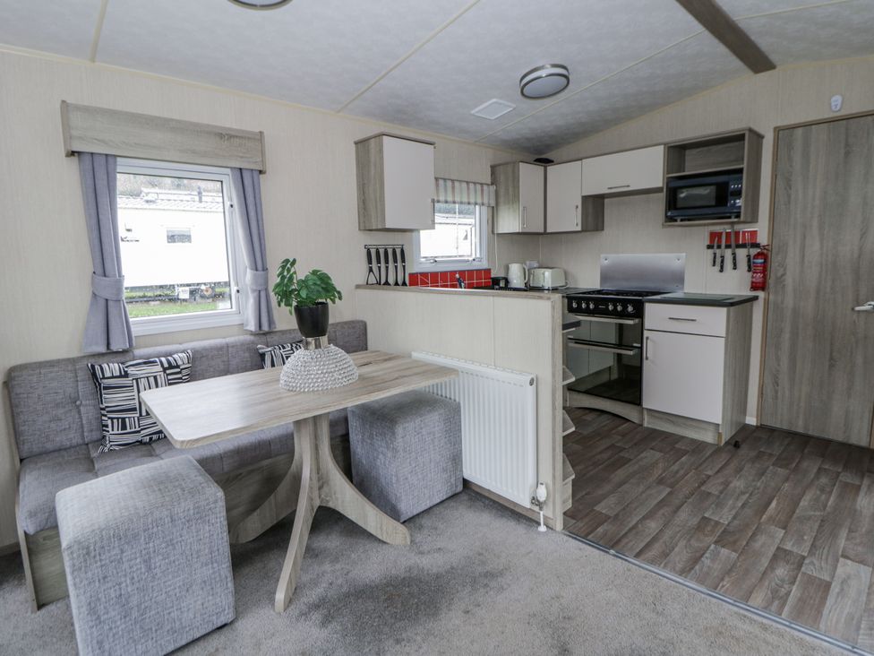 A kitchen with a dining area and appliances at Brynowen Holiday Park - Holiday Accommodation 22432 Borth