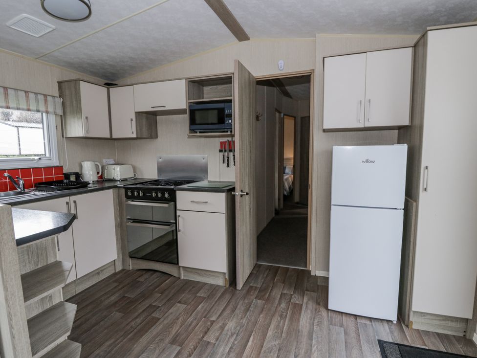 A kitchen with appliances and cabinetry at Brynowen Holiday Park - Holiday Accommodation 22432 Borth