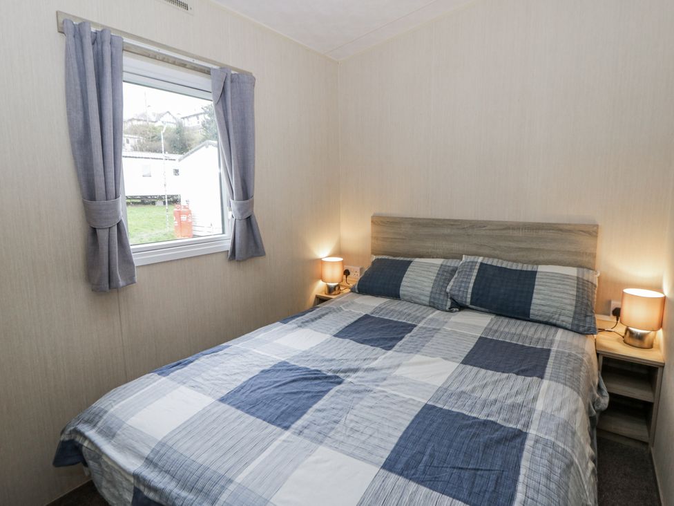 A bedroom featuring a bed with a checkered blanket at Brynowen Holiday Park - Holiday Accommodation 22432 Borth