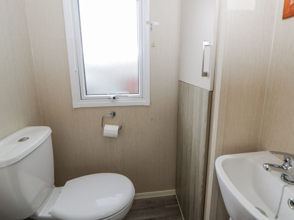 A bathroom with a toilet and a sink at Brynowen Holiday Park - Holiday Accommodation 22432 Borth