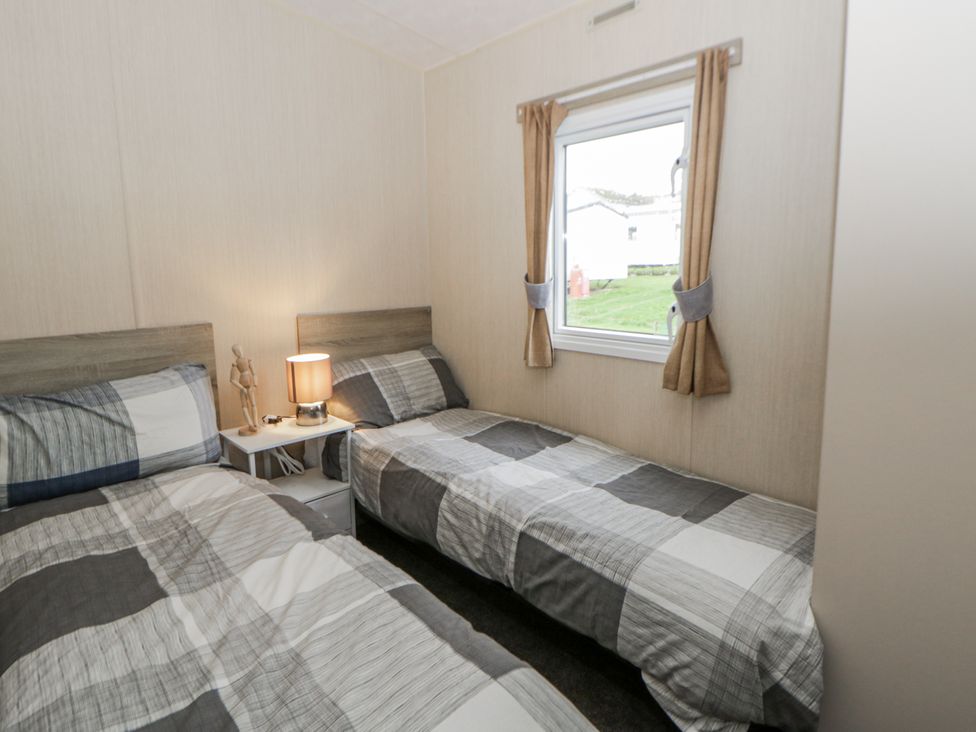 A bedroom with two beds and a window at Brynowen Holiday Park - Holiday Accommodation 22432, Borth