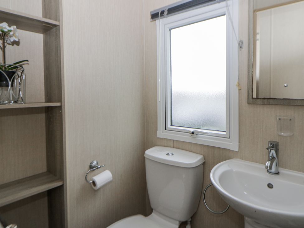 A bathroom with a toilet and sink at Brynowen Holiday Park - Holiday Accommodation 22432 Borth