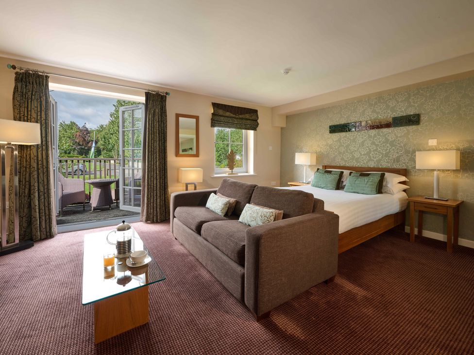 A bedroom with a sofa and bed at Ullswater Apartment in Penrith
