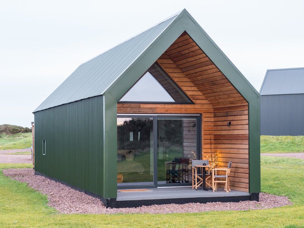 A cabin with a deck and table outside at The Weir in North Berwick