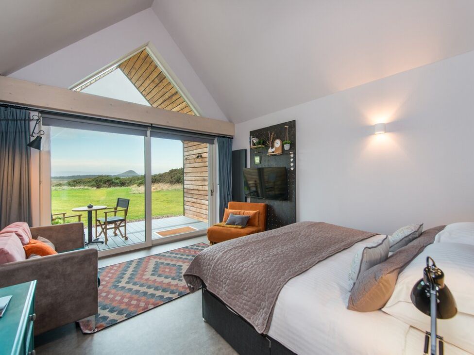 A bedroom with a bed and seating area at The Weir in North Berwick